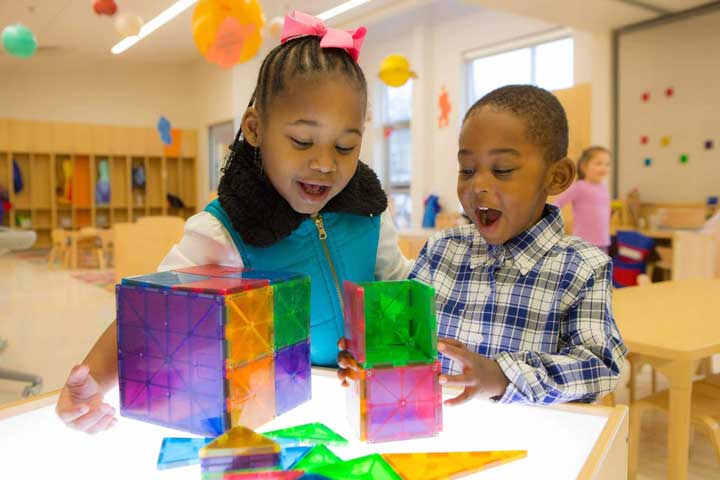 Two children working together with magnetic tile blocks