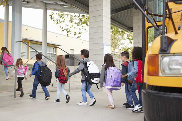 Elementary school kids arrive at school from the school bus