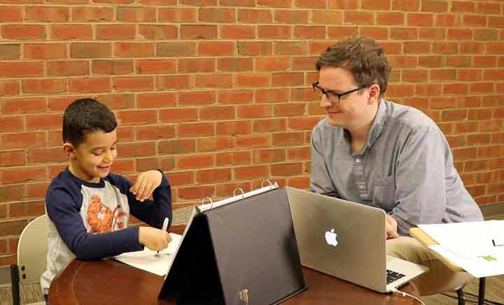 Young boy completing the Early Mathematics Assessment