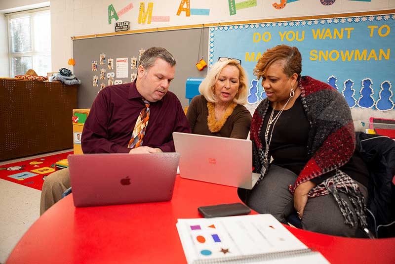 Teachers and principal reviewing data together.