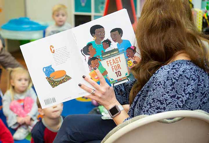 Teacher holding up book to class