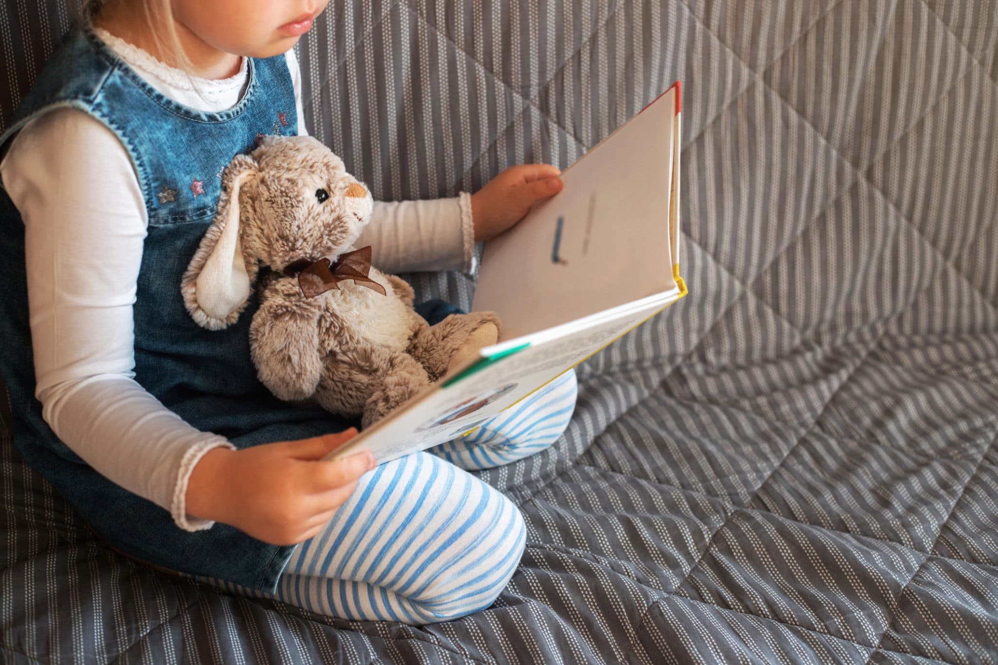 Child reading with stuffed animal