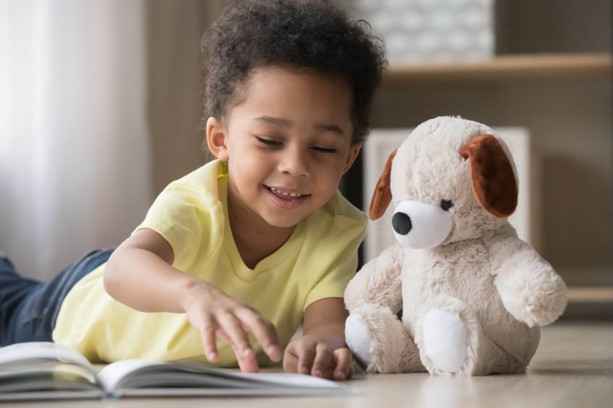 Young boy reading with Teddy bear