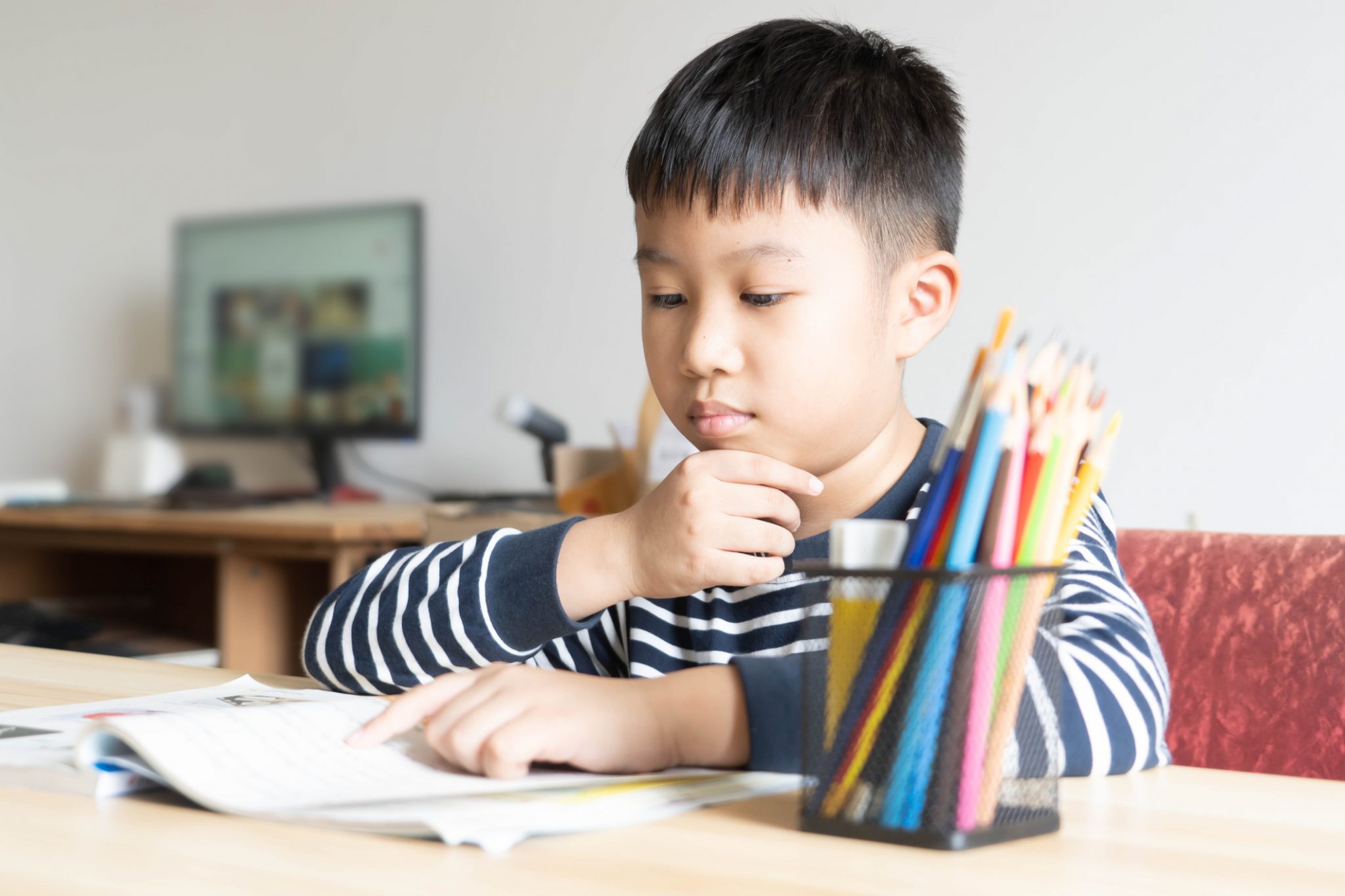 Boy thinking with pencil in hand