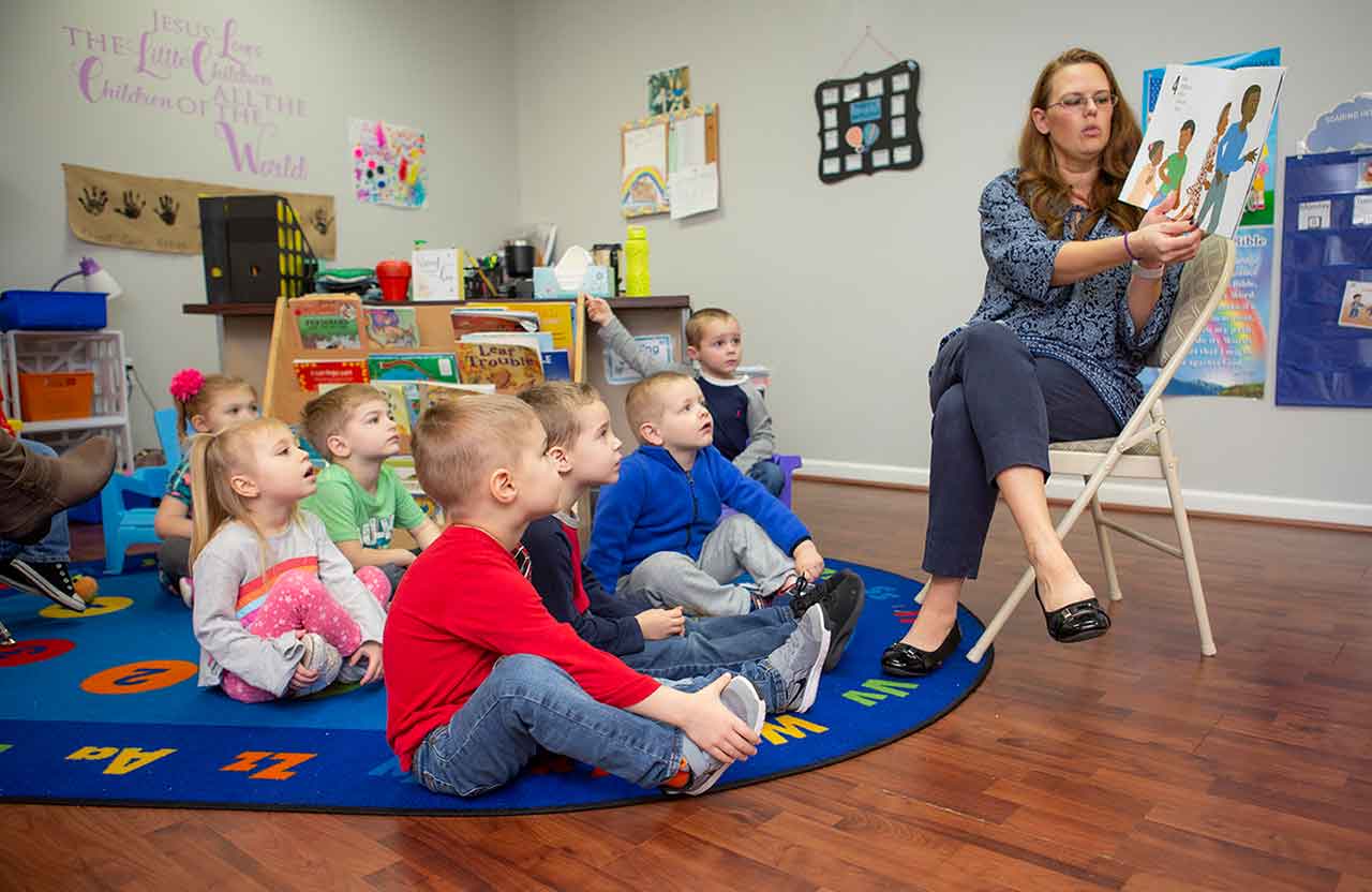 An educator reading a book to students