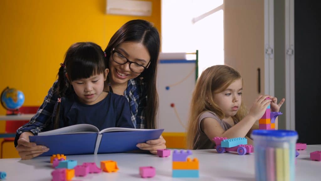 A child and educator reading together during a math activity