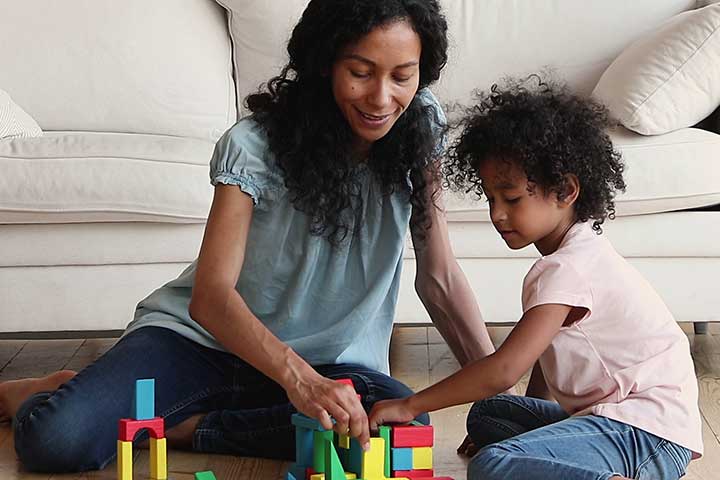 caregiver and child building with shapes and blocks