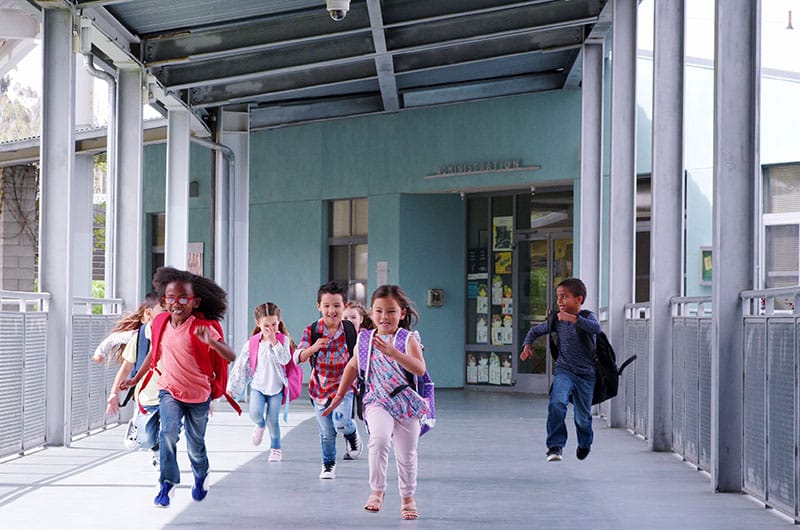 children running together in an open corridor